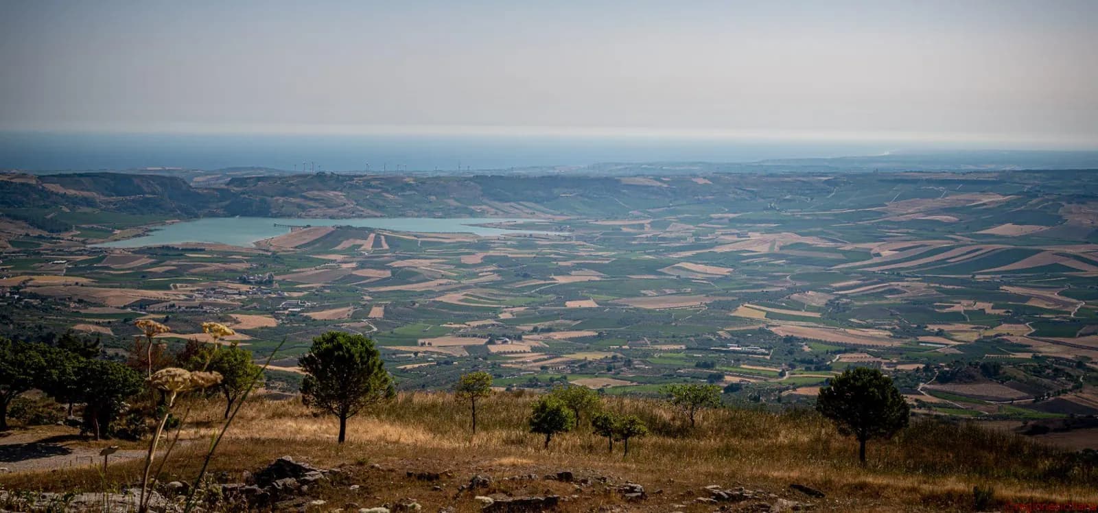 Panorama of the countryside around Sambuca, with a lake and the sea beyond